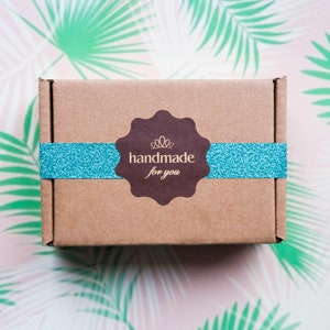 May include: A brown cardboard box with a blue ribbon and a brown label that says "handmade for you".