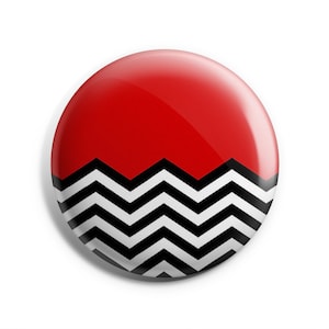 May include: A red and black button with a chevron pattern. The button is round and has a glossy finish.