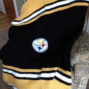 May include: Black and gold crocheted throw blanket with a Steelers logo in the center.