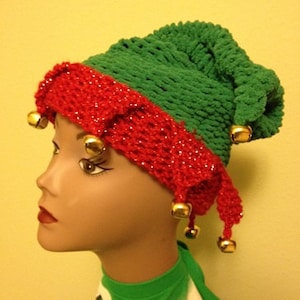 May include: Green and red crocheted elf hat with gold jingle bells. The hat has a pointed top and a curled brim.