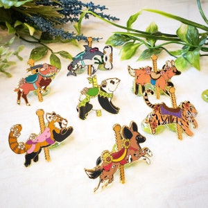 K&ouml;nnte beinhalten: Ein Set mit zehn Emaille-Pins, die verschiedene Tiere auf einem Karussell zeigen. Die Pins sind farbenfroh und detailliert, jedes Tier hat ein einzigartiges Design. Zu den Tieren geh&ouml;ren ein Panda, ein Rotpanda, ein Fuchs, ein Tiger, ein Hammerhai und ein Hund.