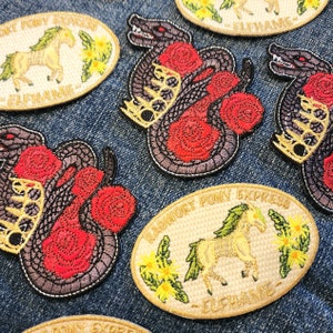 May include: A collection of embroidered iron-on patches featuring a black snake with red roses, a white pony with green leaves, and the text "Ragnarok Pony Express" in gold thread.
