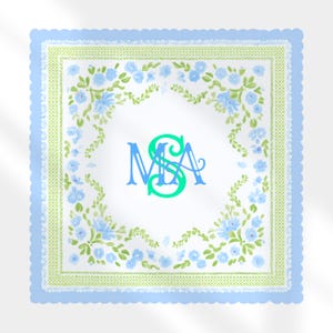 May include: A square, white handkerchief with a light blue scalloped border. The handkerchief features a green and white floral design with blue flowers and a monogram in the center. The monogram is in blue and green.