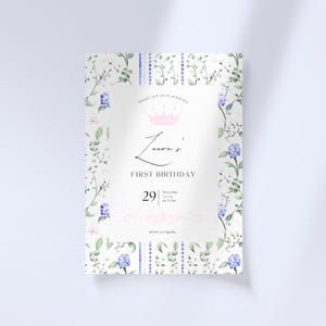 Puede incluir: Una invitaci&oacute;n blanca con un borde floral y una corona rosa. El texto dice "Por favor, &uacute;nase a nosotros para celebrar el primer cumplea&ntilde;os de Laura, s&aacute;bado 29 de julio a las 3 pm. RSVP a Claudia."