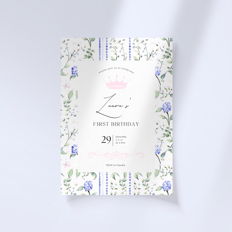 Puede incluir: Una invitaci&oacute;n blanca con un borde floral y una corona rosa. El texto dice "Por favor, &uacute;nase a nosotros para celebrar el primer cumplea&ntilde;os de Laura, s&aacute;bado 29 de julio a las 3 pm. RSVP a Claudia."