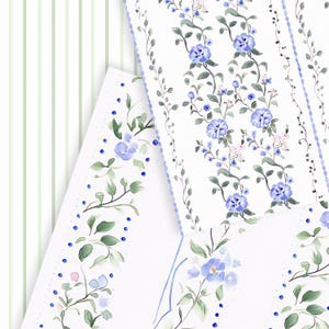 Puede incluir: Tres hojas de papel blanco con patrones florales azules. Las hojas tienen un borde festoneado y est&aacute;n decoradas con flores azules, hojas verdes y peque&ntilde;os puntos azules.