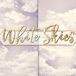 May include: A white background with a gold foil arrow pointing to the right. The words "White Skies" are written in gold foil on the arrow.