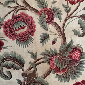 May include: A vintage fabric with a floral pattern. The fabric features a repeating design of pink and green flowers on a cream background.