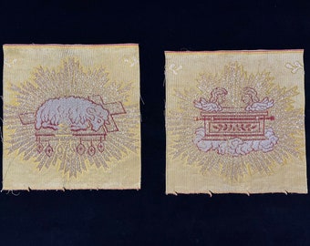 May include: Two embroidered fabric squares with a gold background and silver glitter. The left square features a white lamb lying on a red cross. The right square features a red ark of the covenant with two white angels on either side.