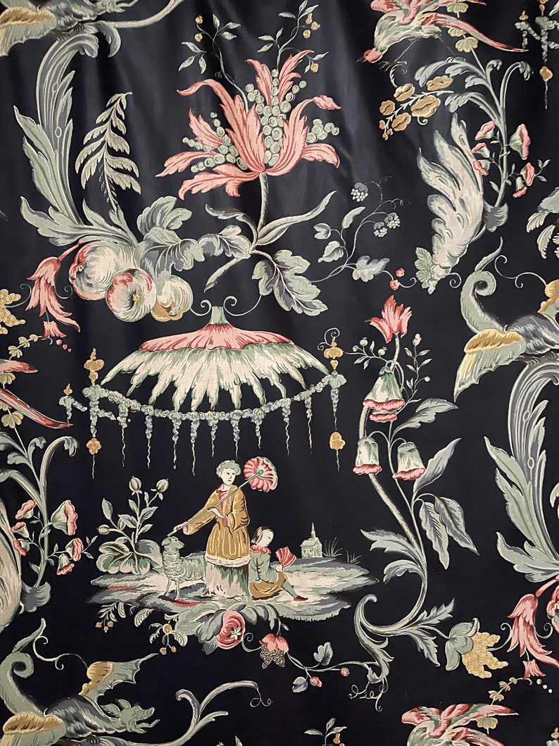 May include: Black fabric with a floral pattern featuring pink and green flowers, leaves, and a whimsical scene with figures under a canopy.