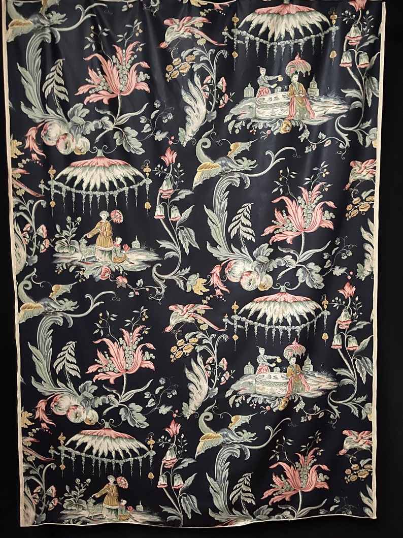May include: Black fabric with a repeating pattern of pink flowers, green leaves, and white birds. The pattern also includes small figures of people in a garden setting.