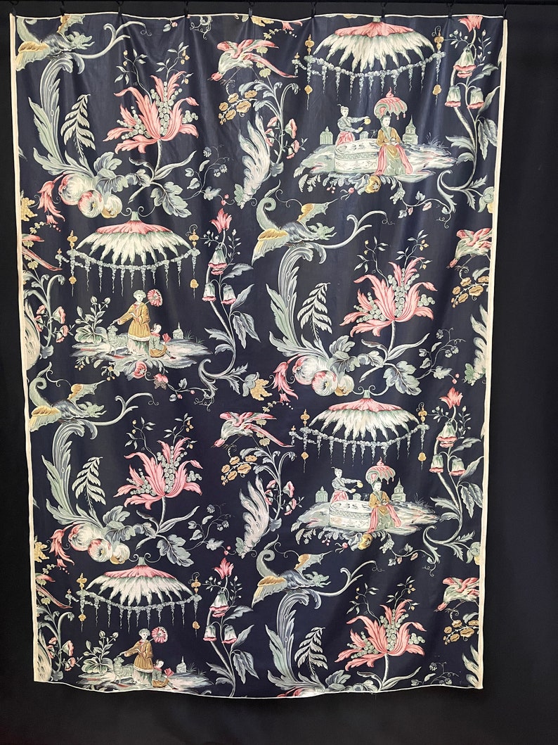 May include: A black fabric with a repeating pattern of pink flowers, green leaves, and white umbrellas.  The pattern also includes small figures in white and yellow.