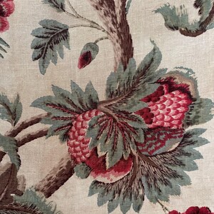 May include: A vintage floral fabric with a cream background and a repeating pattern of red and green flowers. The flowers are stylized and have a slightly abstract look. The fabric has a linen texture.