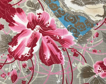 May include: A textile fabric featuring a large pink and deep red hibiscus-like flower pattern on a textured gray background with thin red lines. A section of blue fabric with a gold and black dragon illustration and cloud motifs is visible.