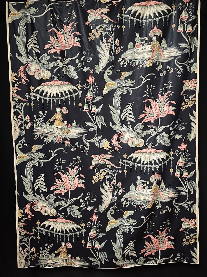 May include: A black fabric with a repeating pattern of pink and green flowers, birds, and figures in a Chinese garden setting.