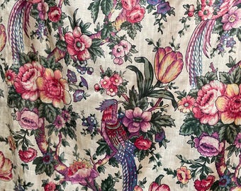 Puede incluir: Una tela beige con un patrón floral que presenta flores rosas, amarillas y moradas, hojas verdes y pájaros coloridos.