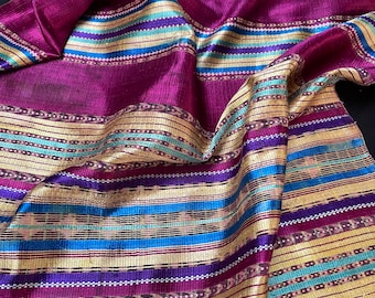 May include: A close-up of a purple and gold striped fabric with a woven pattern. The fabric is soft and silky, and the colors are vibrant.
