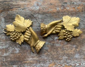 アンティークの金箔彫刻が施された木製の針とブドウの壁飾りのペア