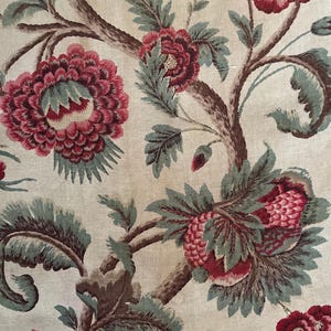 May include: A vintage fabric with a floral pattern. The fabric features a repeating design of a tree with large red flowers and green leaves.