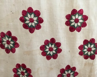 May include: White fabric with a repeating pattern of red and green embroidered flowers.