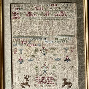 以下が含まれることがあります： 白い背景にカラフルな刺繍が施されたアンティークなサンプラー。サンプラーには、さまざまな花のモチーフ、2頭の鹿、そして「PESTtY/ZJ2346 アラン1011121314 Lorave me Wisdom TO DIBLE MY W BCGORIČKIS HORSET LEIGU pays Fauve is orcEXTFUL vain Butx Brauty is That searcせる、 PERFLOP Furtst 1722/2/3 that con mac ar dratou」というテキストが刺繍されています。