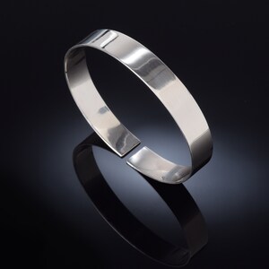 May include: A silver bangle bracelet with a smooth, polished finish.
