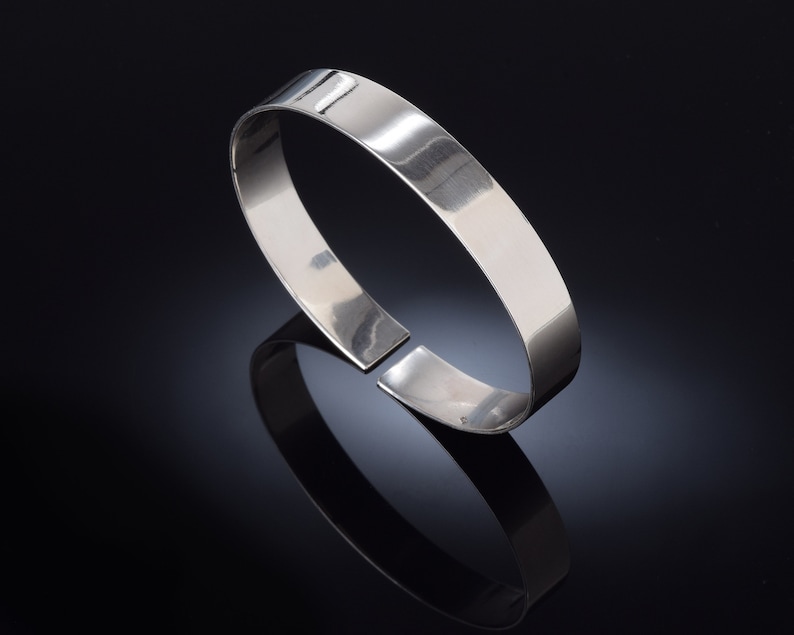 May include: A silver bangle bracelet with a smooth, polished finish.