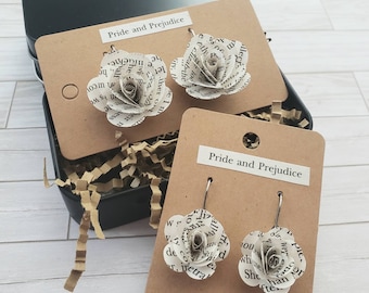 May include: Two pairs of earrings featuring paper roses made from pages of the book "Pride and Prejudice". The earrings are displayed on brown cards with the book title printed on them.