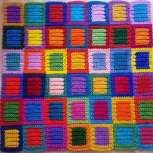 May include: A colorful crocheted blanket with squares of different colors, including red, orange, yellow, green, blue, purple, and pink.