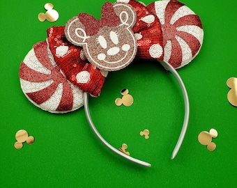 Puede incluir: Diadema de orejas de Minnie Mouse con temática de caramelo de menta roja y blanca con una silueta de cabeza de Minnie Mouse marrón en el centro.