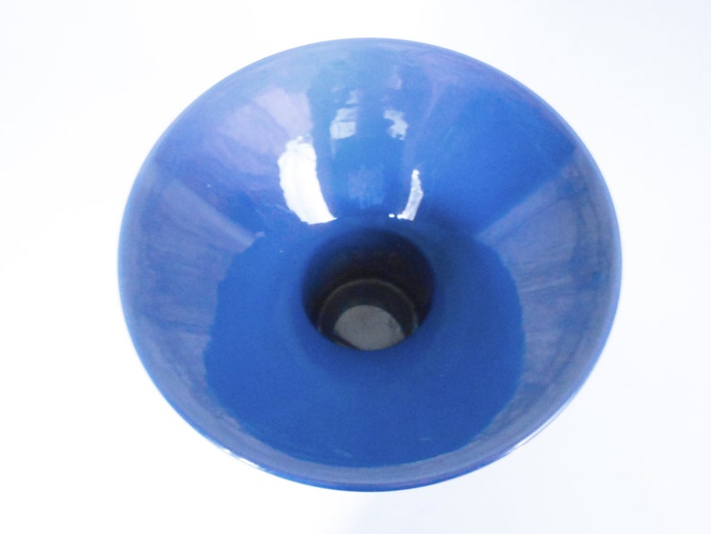 K&ouml;nnte beinhalten: Eine blaue Keramikvase mit einer breiten, ausgestellten &Ouml;ffnung und einem schmalen Boden. Die Vase hat eine glatte, gl&auml;nzende Oberfl&auml;che.