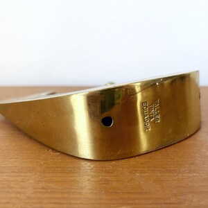 May include: A gold-colored metal paperweight shaped like a boat with the text "Taller Tinta Ecuador" engraved on the side.