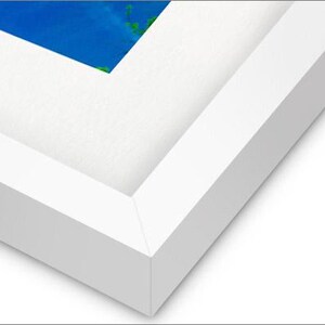 May include: Close-up of a white picture frame with a beveled edge. The frame is made of wood and has a smooth finish.