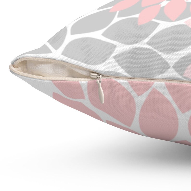 May include: A pink and gray patterned throw pillow with a zipper closure.