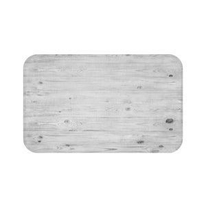 May include: Rectangular wooden surface with rounded corners. The surface is made of light gray wood planks with visible grain and knots, creating a rustic, textured appearance. The overall design is simple and neutral.