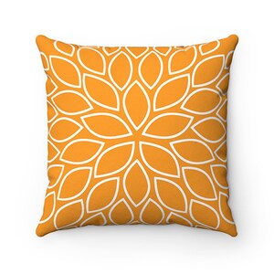May include: Orange cushion with a white geometric pattern of overlapping petals.