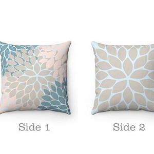Puede incluir: Coj&iacute;n de dos caras con un patr&oacute;n floral. Un lado presenta un dise&ntilde;o floral azul claro y rosa, mientras que el otro lado presenta un dise&ntilde;o floral azul claro y beige.