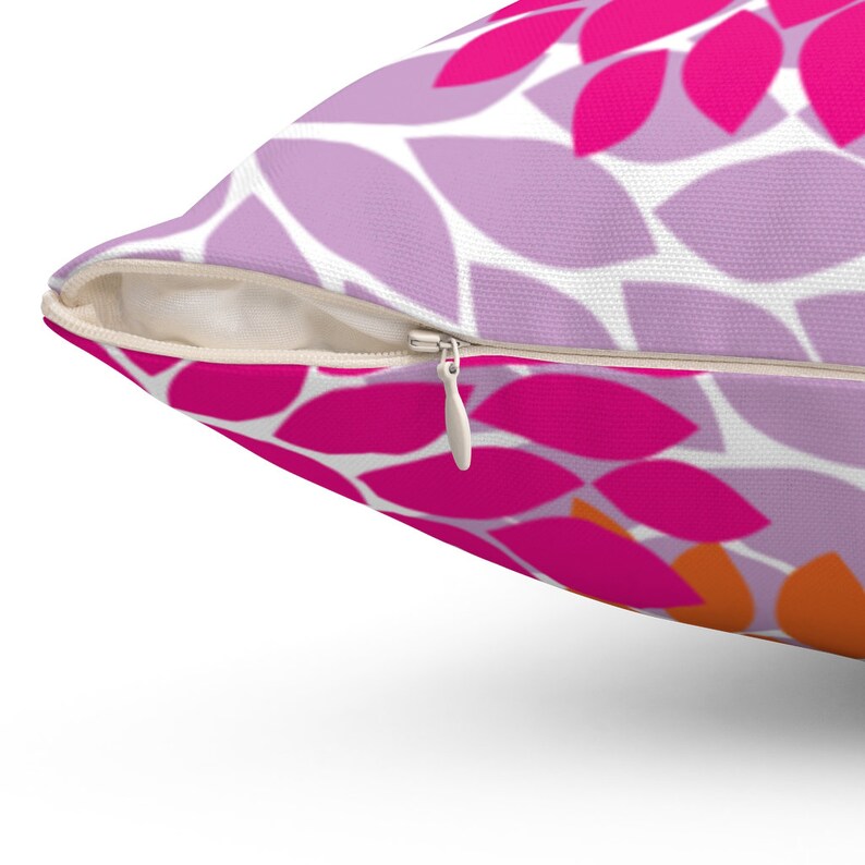 Puede incluir: Una almohada de tiro con estampado rosa y naranja con cierre de cremallera.