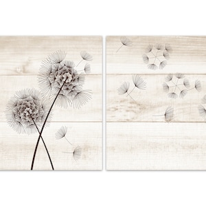 May include: Two black and white dandelion illustrations on a white wood background. The dandelions are in different stages of blowing away. The background is a light wood with a white wash.