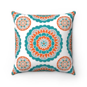 May include: A white throw pillow with a repeating pattern of teal, orange, and gray mandala designs.