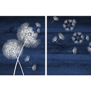 May include: Two blue wood panels with white dandelion illustrations. The left panel shows two dandelions with seeds blowing in the wind. The right panel shows several dandelions with seeds blowing in the wind.