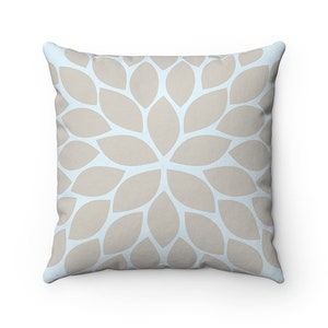 Puede incluir: Una almohada decorativa con un fondo azul claro y un patr&oacute;n floral beige.
