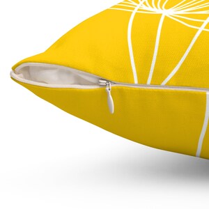 May include: A yellow throw pillow with a white geometric design. The pillow has a zipper closure.