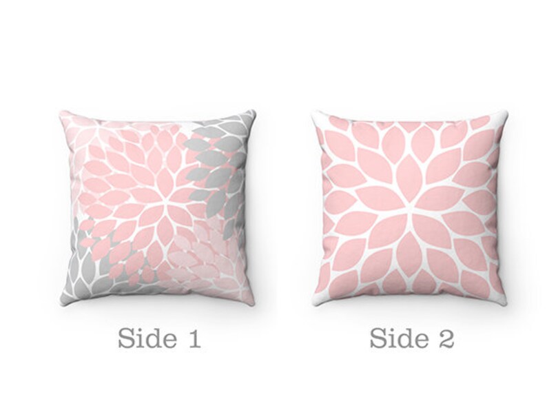 May include: Two-sided throw pillow with a pink and gray floral pattern. One side features a pink and gray floral design, while the other side is a solid pink floral pattern.