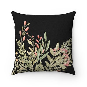 May include: Black throw pillow with a watercolor design of green leaves and pink berries.