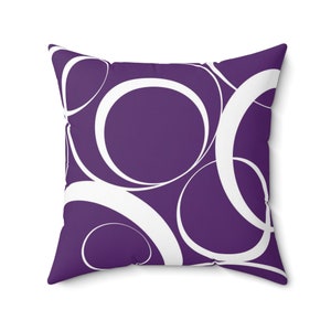 May include: Purple throw pillow with a white geometric pattern of overlapping circles.