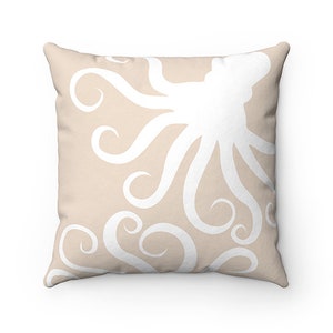 May include: A beige throw pillow with a white octopus design. The octopus is stylized with swirling tentacles.