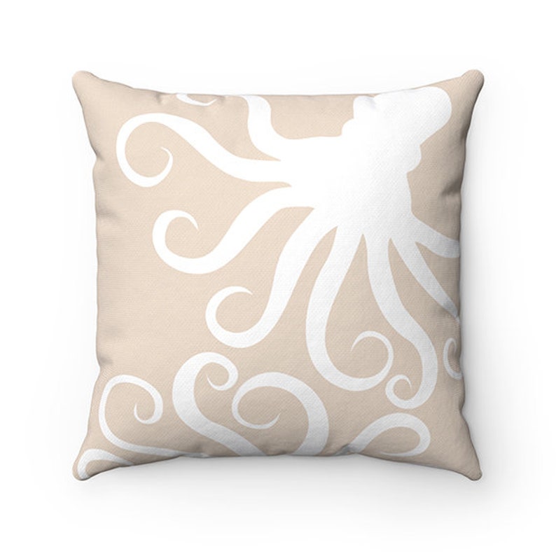 May include: A beige throw pillow with a white octopus design. The octopus is stylized with swirling tentacles.
