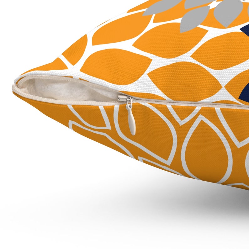 May include: A yellow throw pillow with a white geometric pattern. The pillow has a zipper closure.