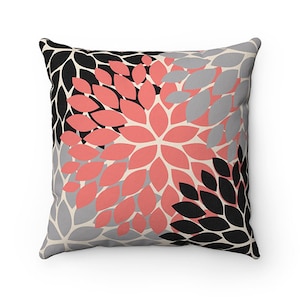 May include: A decorative throw pillow with a floral pattern in shades of black, gray, and coral.